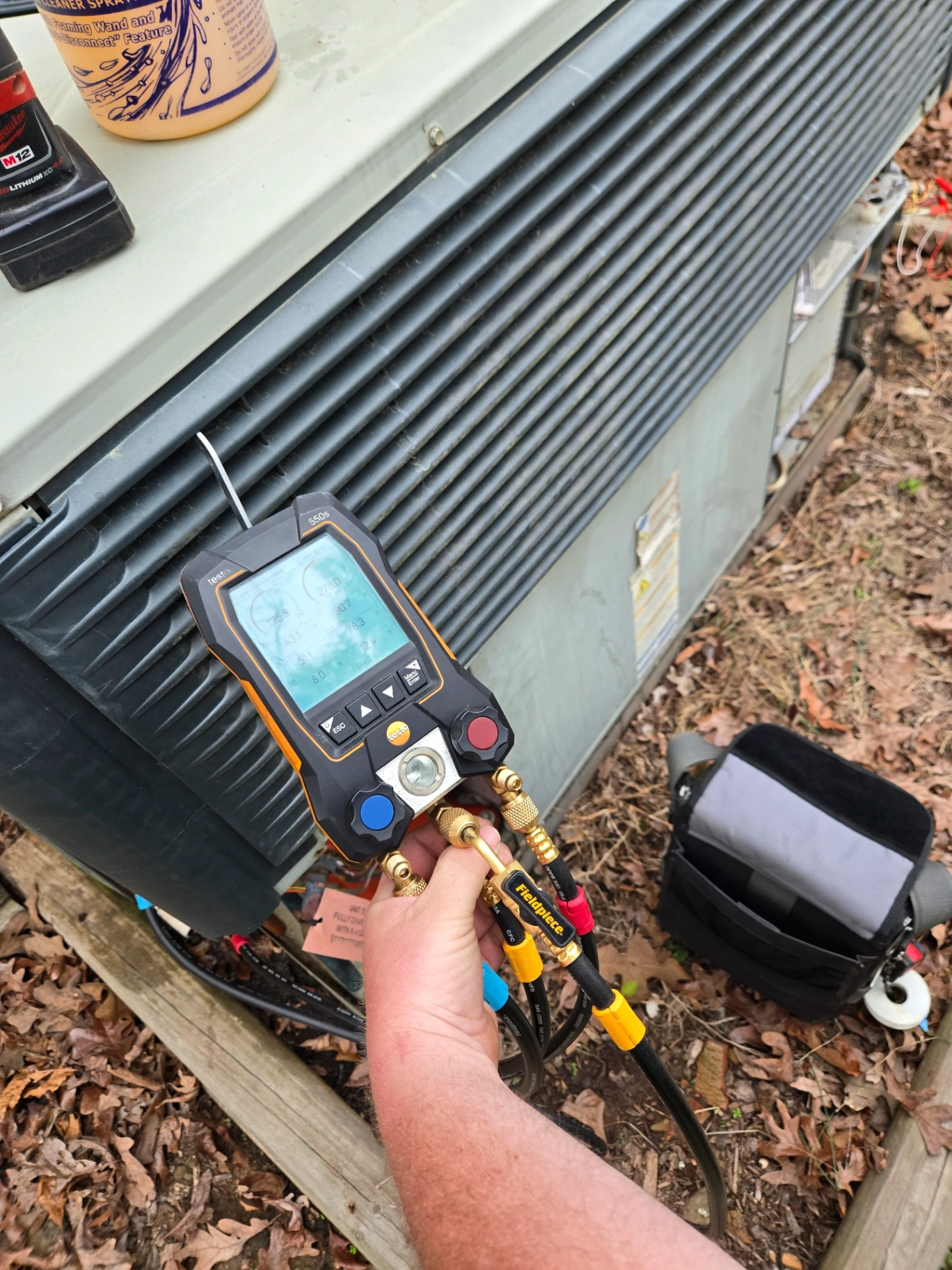 Dependable HVAC technician testing refrigerant pressure during AC repair in Albemarle NC