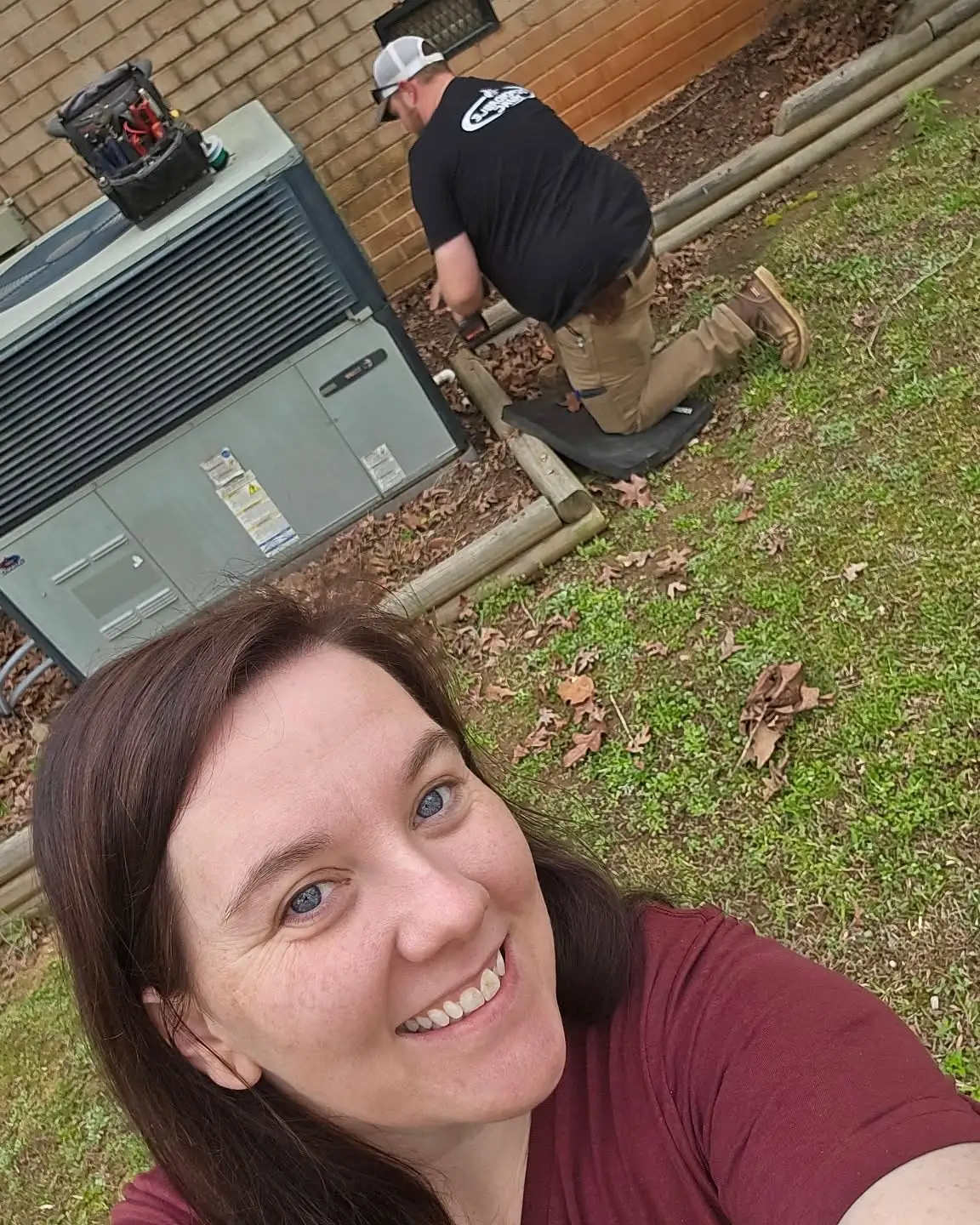 Happy Dependable HVAC customer with technician performing AC maintenance service in North Carolina